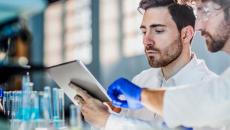 Healthcare workers looking at a tablet in a lab