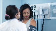 Doctor takes patient's blood pressure 