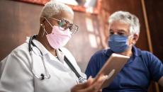 Doctor talking to senior male patient in a home visit