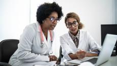 Doctors using a laptop to join a digital conference.