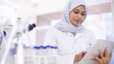 Scientist in a lab surrounded by microscopes