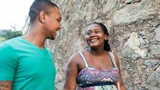 Two people walking together while looking at each other and smiling