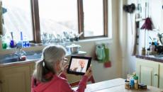 person holding tablet sitting at table 