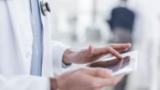 Healthcare provider's hands holding a tablet