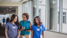 three people walking together in a hospital