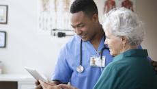 Healthcare provider showing a tablet to a patient