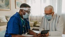 Patient in mask with healthcare worker in PPE