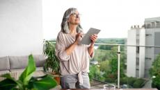 A woman standing at her desk using a tablet