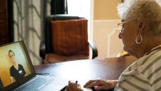 A person talking to a provider via a video chat on a laptop