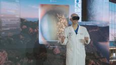 Healthcare provider wearing an augmented reality headset and surrounded by a virtual environment