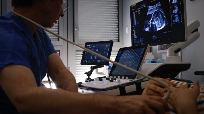 An obstetrician-gynaecologist reading an automated report by Sonio Detect