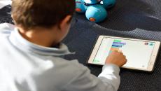 Alt text: A child playing on an iPad