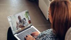 A person talks to a doctor though a video chat on her laptop.