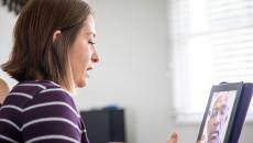 A woman talking to a provider on her tablet