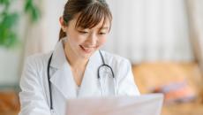 Healthcare provider sitting at a desk looking at a computer