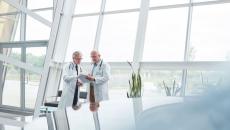 Two healthcare providers in a room with big windows