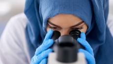 Healthcare provider looking through a microscope