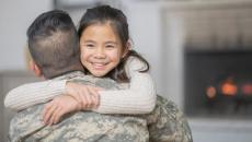 Soldier in uniform with his back turned while hugging someone not in uniform