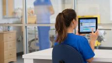 Healthcare provider sitting at a desk in the clinical setting while looking at a computer