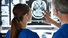 Two healthcare providers looking at a brain scan 