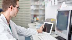 Healthcare professional sitting at a desk looking at a computer