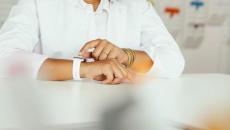 Person sitting at a table with their torso and arms showing with a watch on their wrist