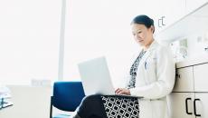 A doctor answering online inquiries on a laptop