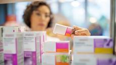  A pharmacist checking medicines on a rack 