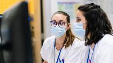 Two hospital staff facing a desktop computer