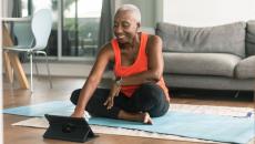 A woman exercising while using a tablet