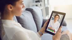 A woman talking to a provider on a tablet